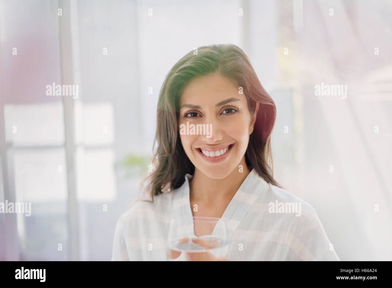Portrait of smiling brunette woman drinking water Banque D'Images