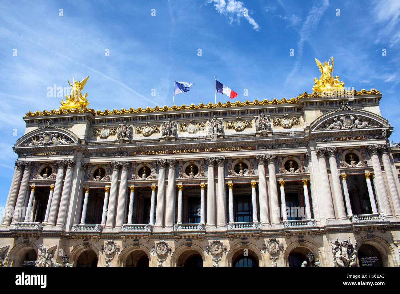 Vue de dessous, historique ancien opéra de Paris avec fond de ciel bleu clair. Drapeaux français et européens brandissent en haut Banque D'Images