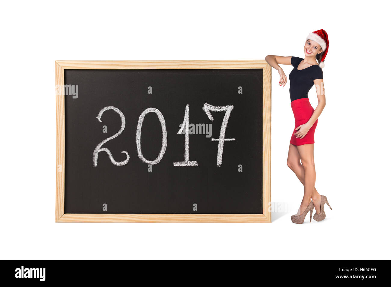 Young business woman in hat noël se trouve près de grand tableau sur l'année nouvelle date. Banque D'Images