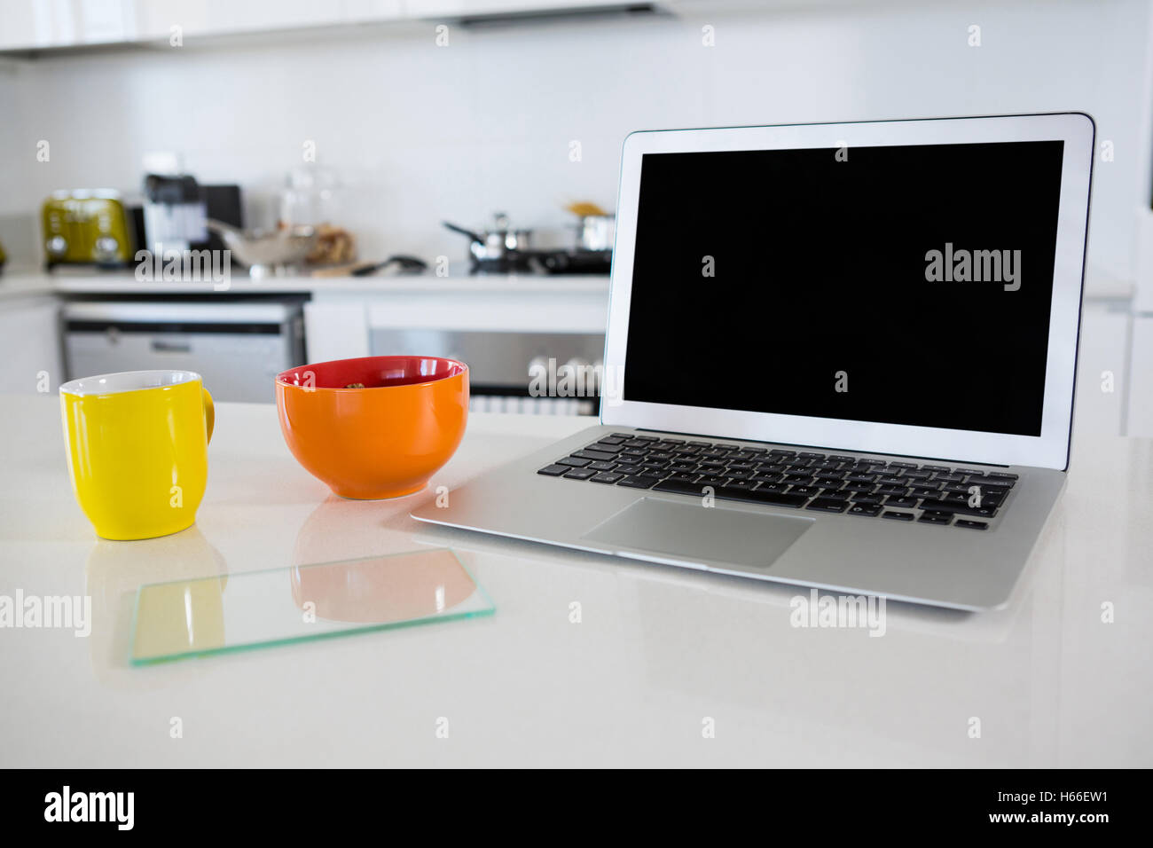 Bol de petit-déjeuner avec café tasse et ordinateur portable dans la cuisine Banque D'Images