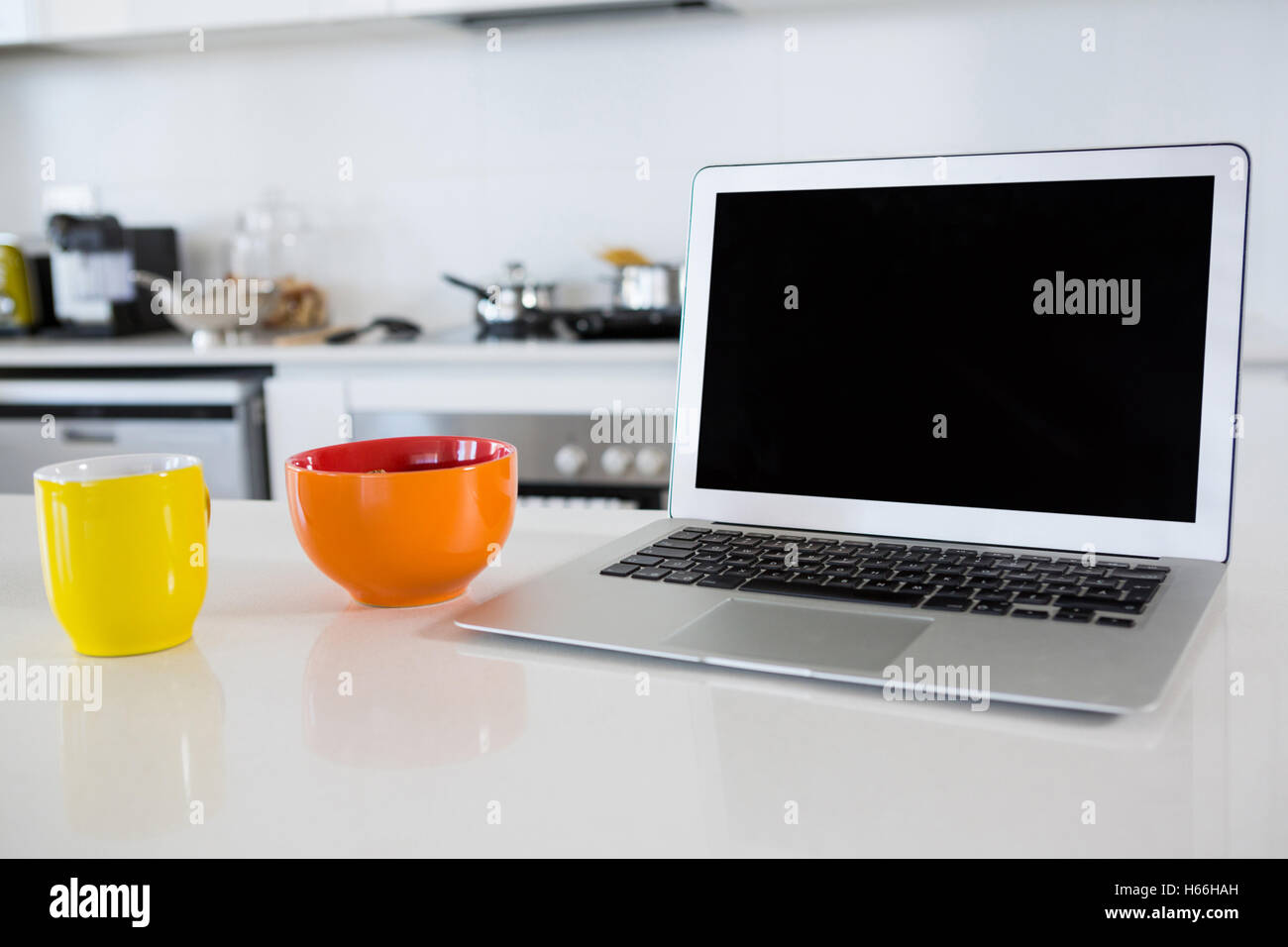 Bol de petit-déjeuner avec café tasse et ordinateur portable dans la cuisine Banque D'Images