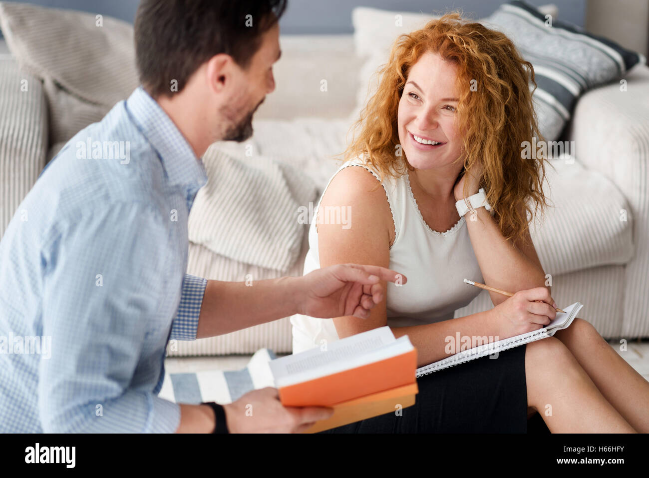 Couple de discuter tout en étant assis sur le plancher Banque D'Images