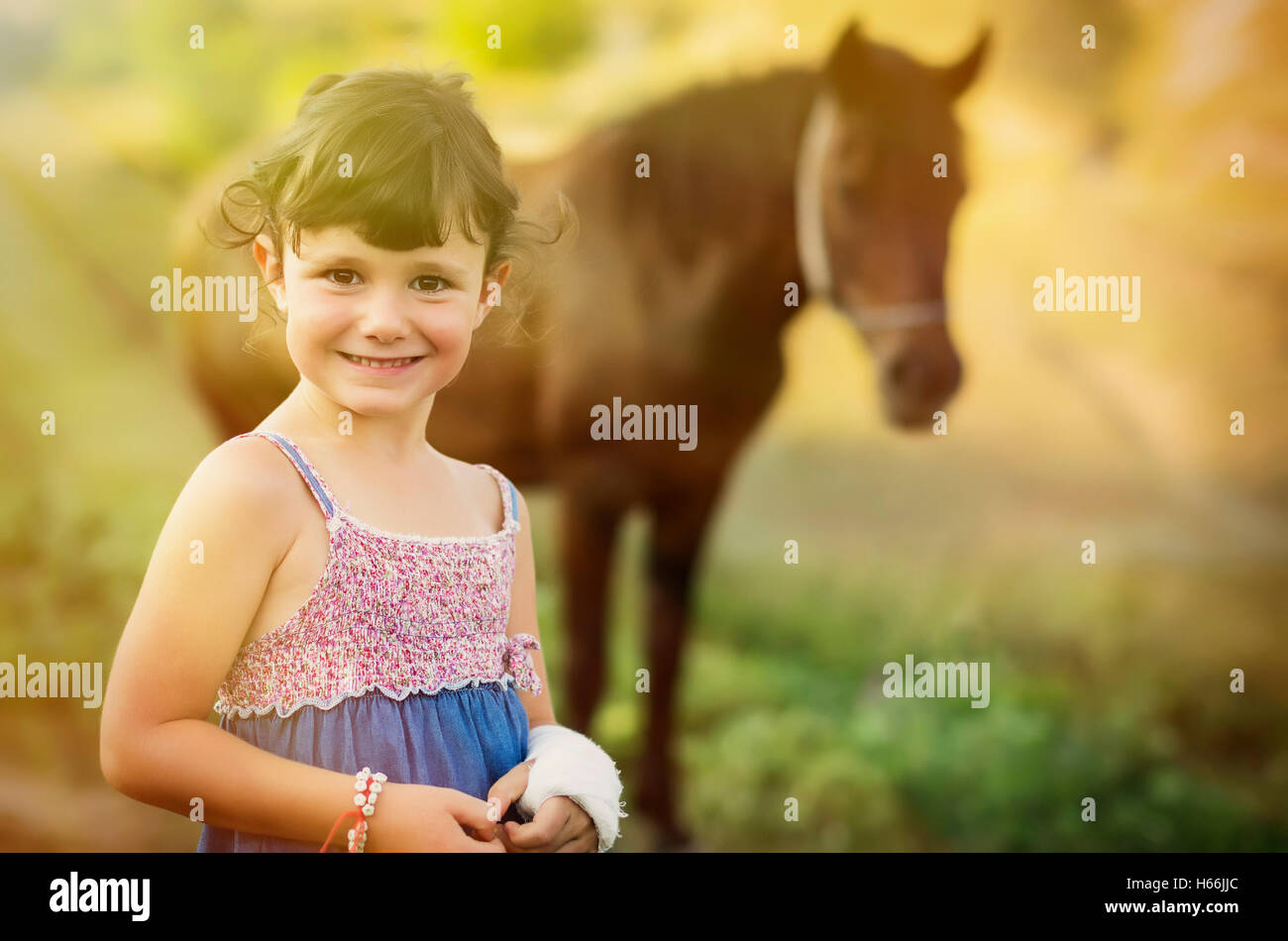 Cinq ans country girl jeu près de son cheval. Banque D'Images