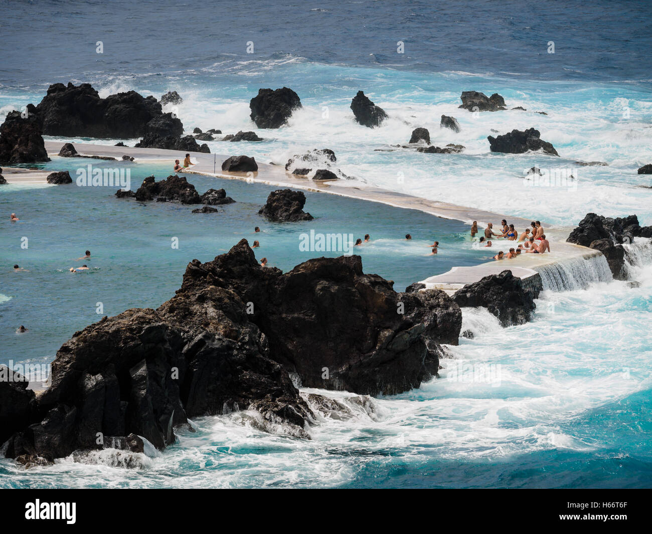 Les touristes et les populations locales bénéficient d'une baignoire en plein air d'eau de mer de l'Océan Atlantique piscines naturelles de Porto Moniz, Madeira Banque D'Images