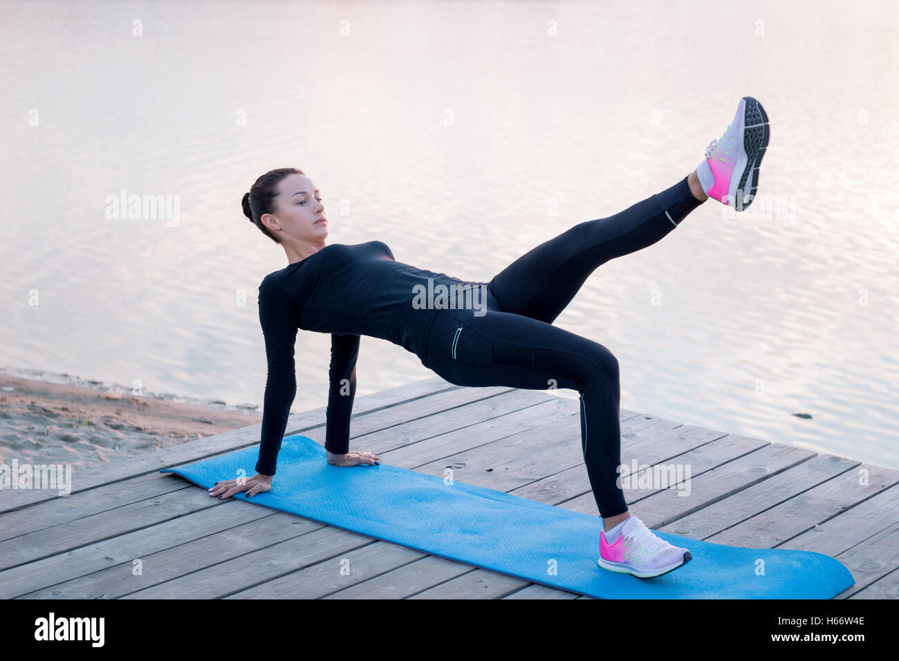 Jolie jeune femme fitness exercices sur pier pendant matin entraînement formation Banque D'Images