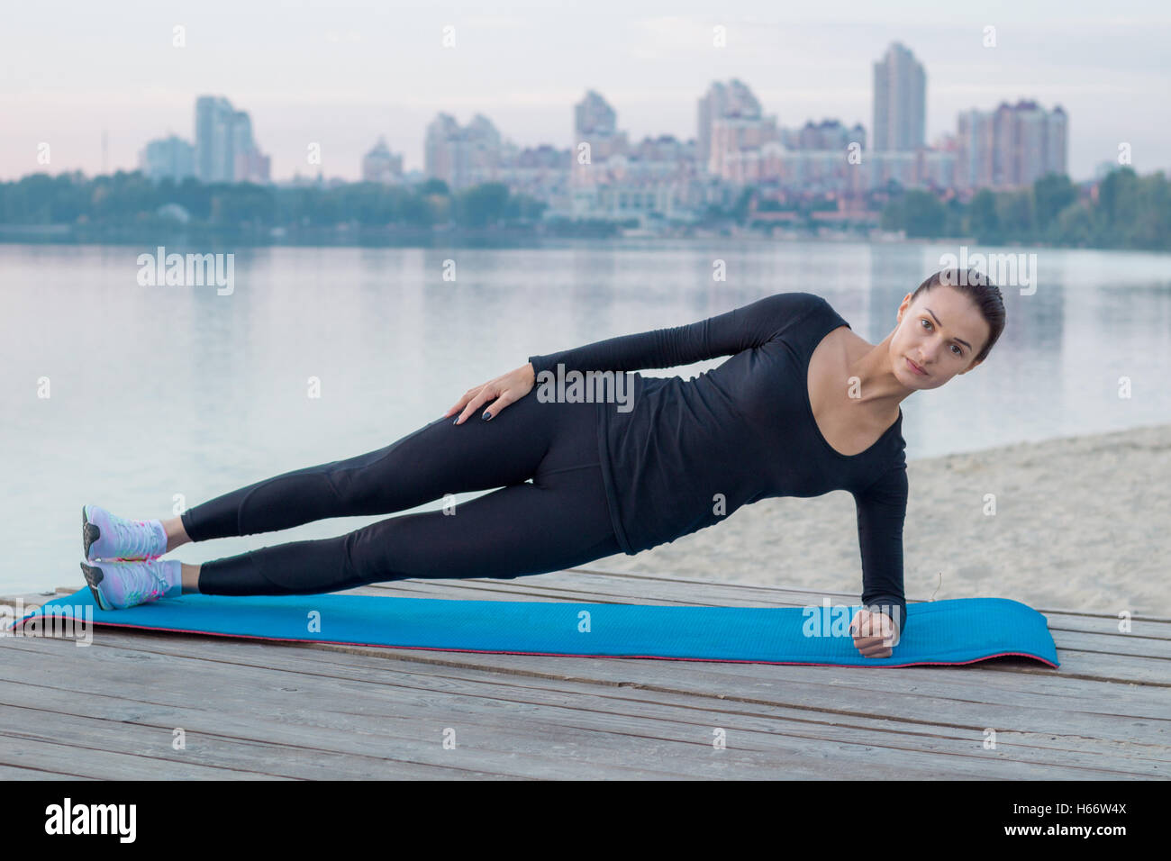Jolie femme exerce sur la jetée au cours de l'entraînement sportif d'entraînement sur river bank Banque D'Images