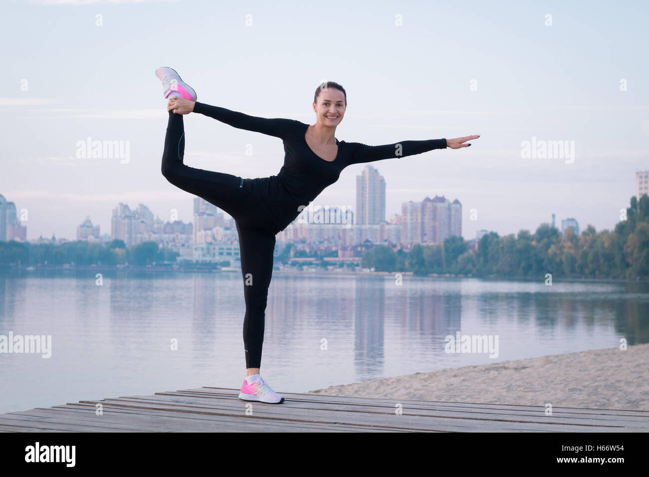 Jolie jeune femme fitness exercices sur pier pendant matin entraînement formation Banque D'Images