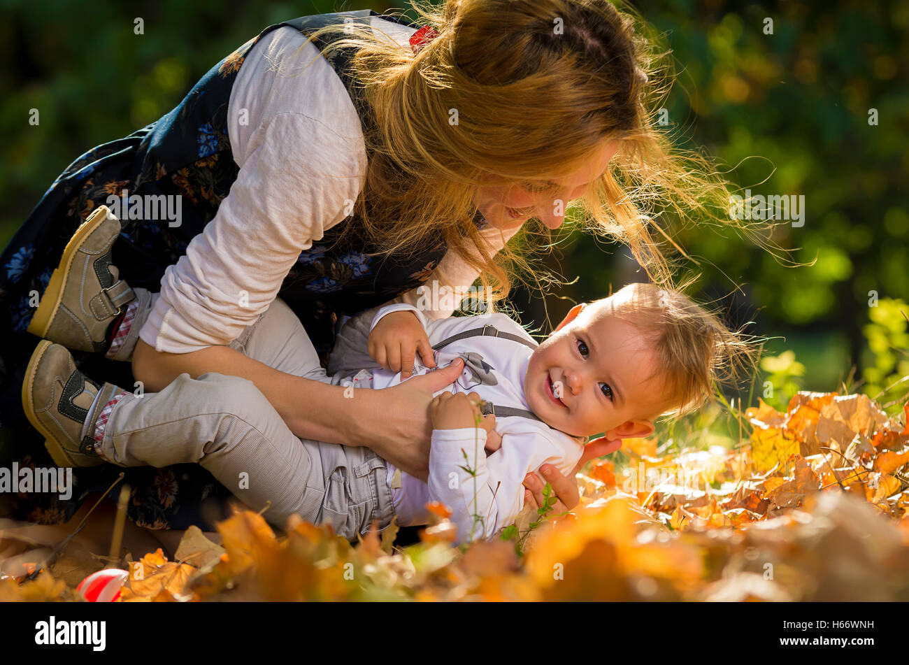 Mère embrassant et en jouant avec son fils en parc. Banque D'Images