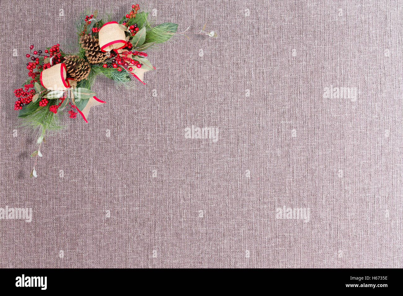 Paire de boucles de Noël et des pommes de pin gris en coin de tissu texturé avec copie espace pour thème d'arrière-plan Banque D'Images