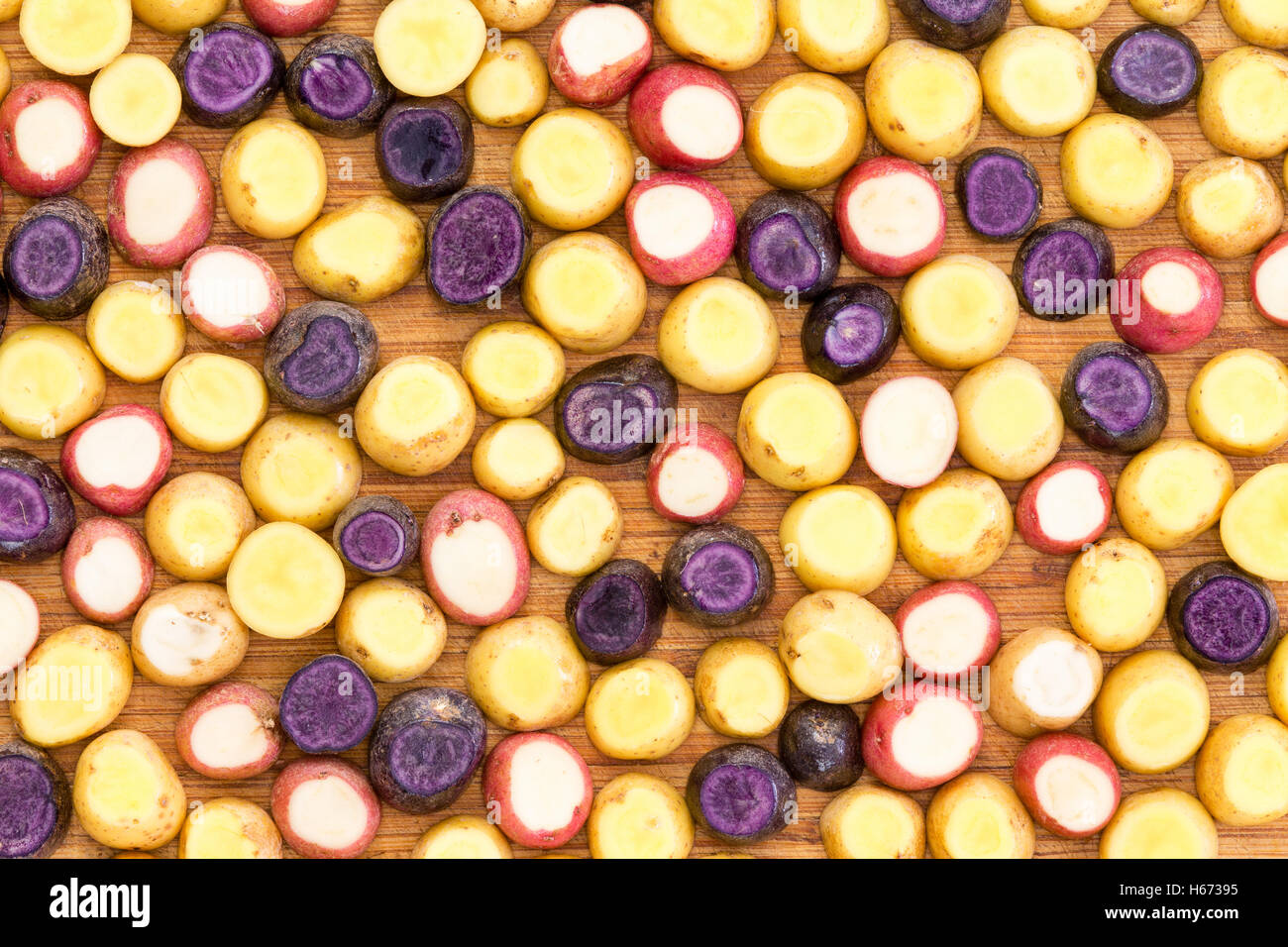 Coupé en tranches et garni de pommes de terre baby mini fond de légumes frais prêts à être grillés dans une vue plein cadre Banque D'Images