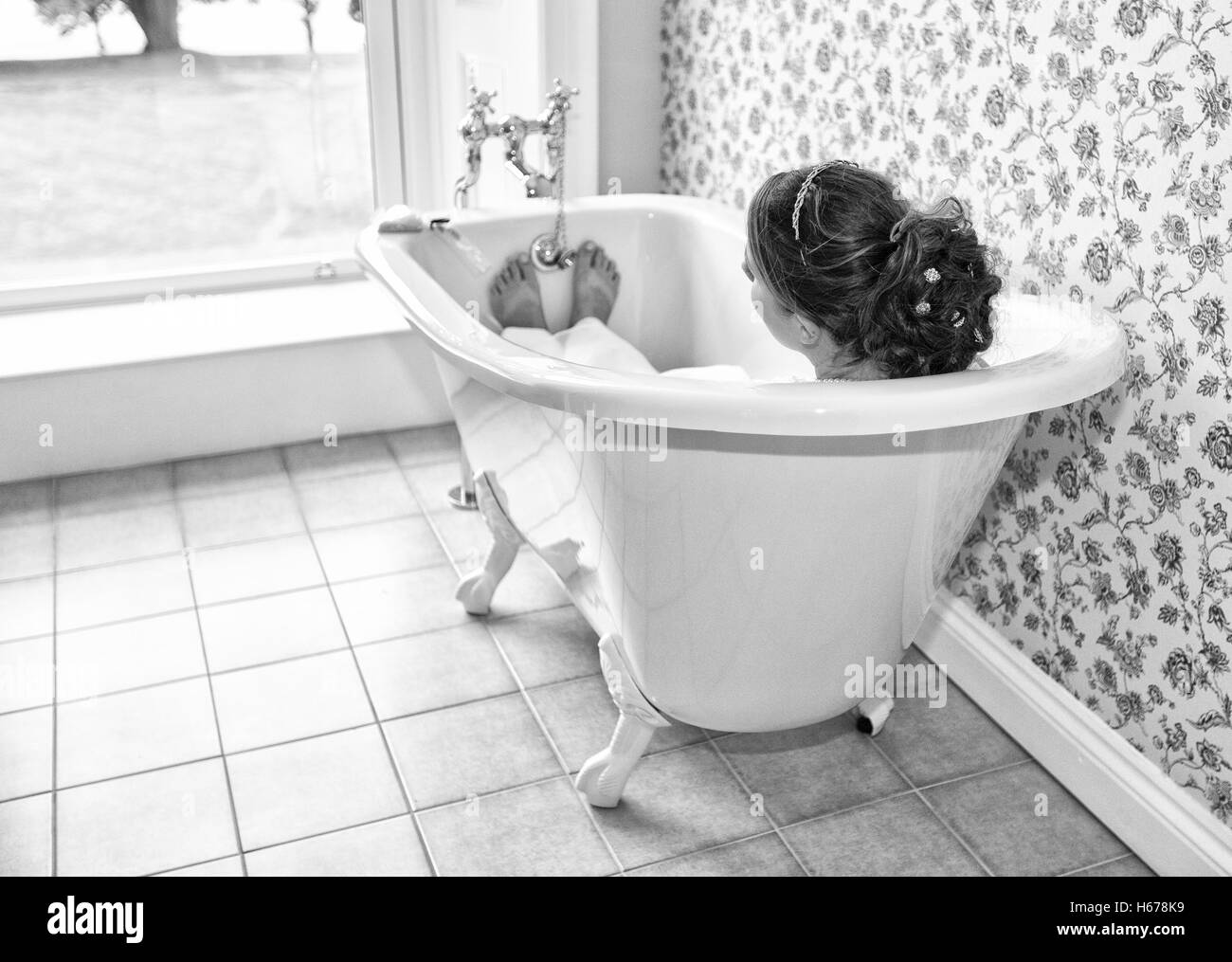 Mariée posé dans la baignoire le jour de son mariage, de prendre un moment pour elle-même. Banque D'Images