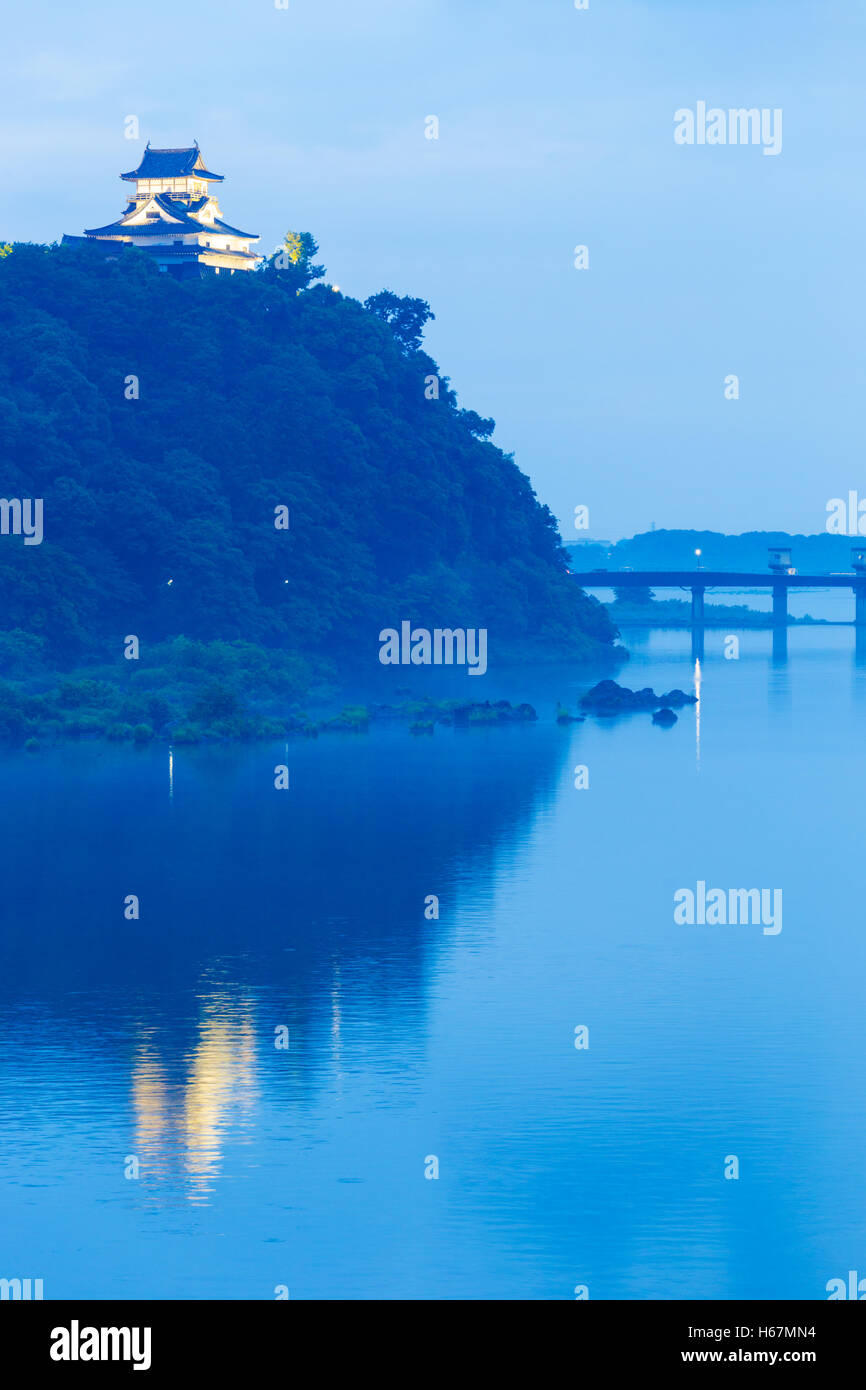 Château d'Inuyama lointain est éclairé par des projecteurs et se reflète dans la rivière Kiso au soir du haut d'une colline forestière à heure bleue Banque D'Images