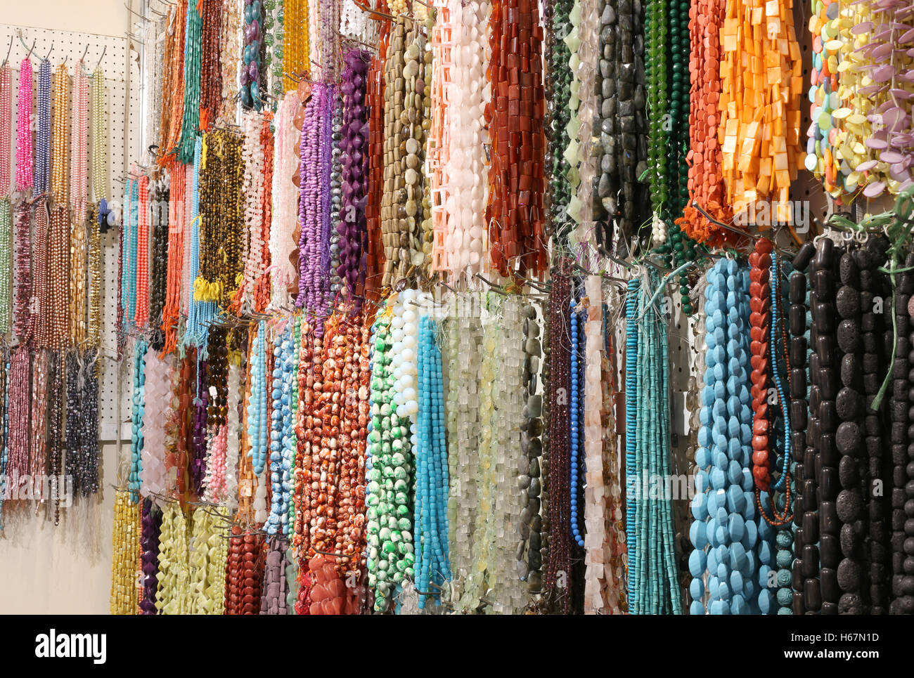 Les colliers en perles chatoyantes et pierres colorées en bijouterie Banque D'Images