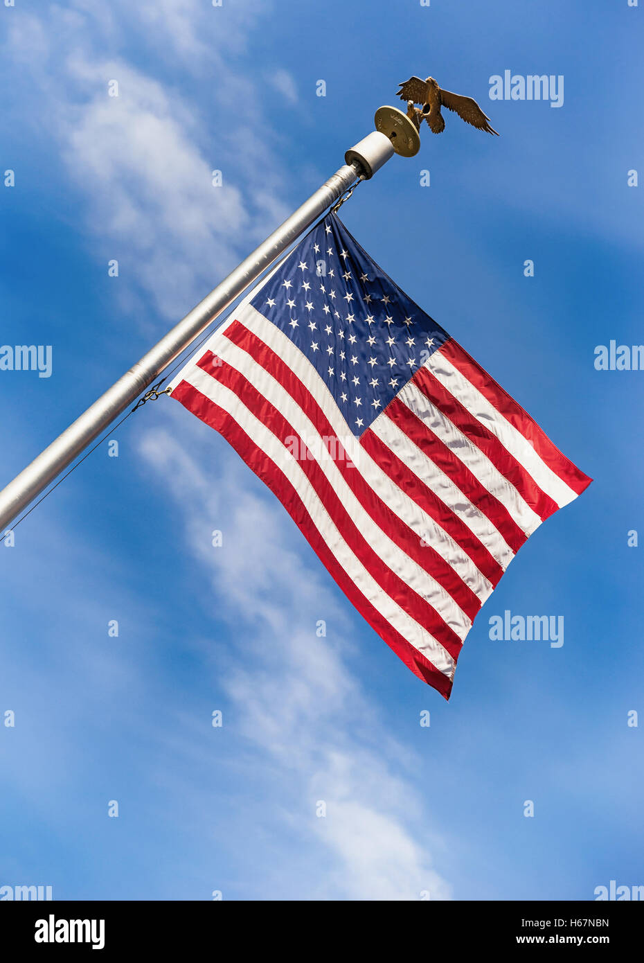 Drapeau américain sur le poteau dans le vent contre fond de ciel bleu Banque D'Images
