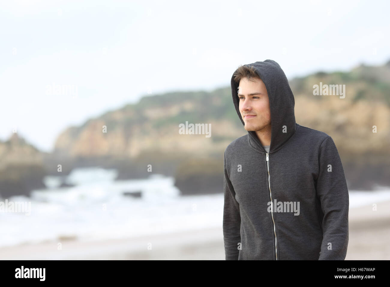 Portrait d'un certain adolescent marche sur la plage, dans un jour de pluie Banque D'Images