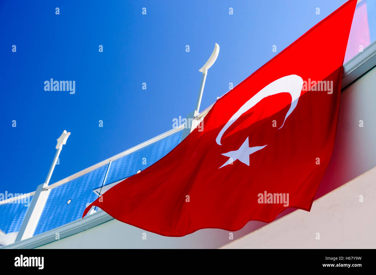 Le drapeau turc avec le Croissant de lune et Vénus étoile sur un fond rouge se bloque à partir d'un balcon. Banque D'Images
