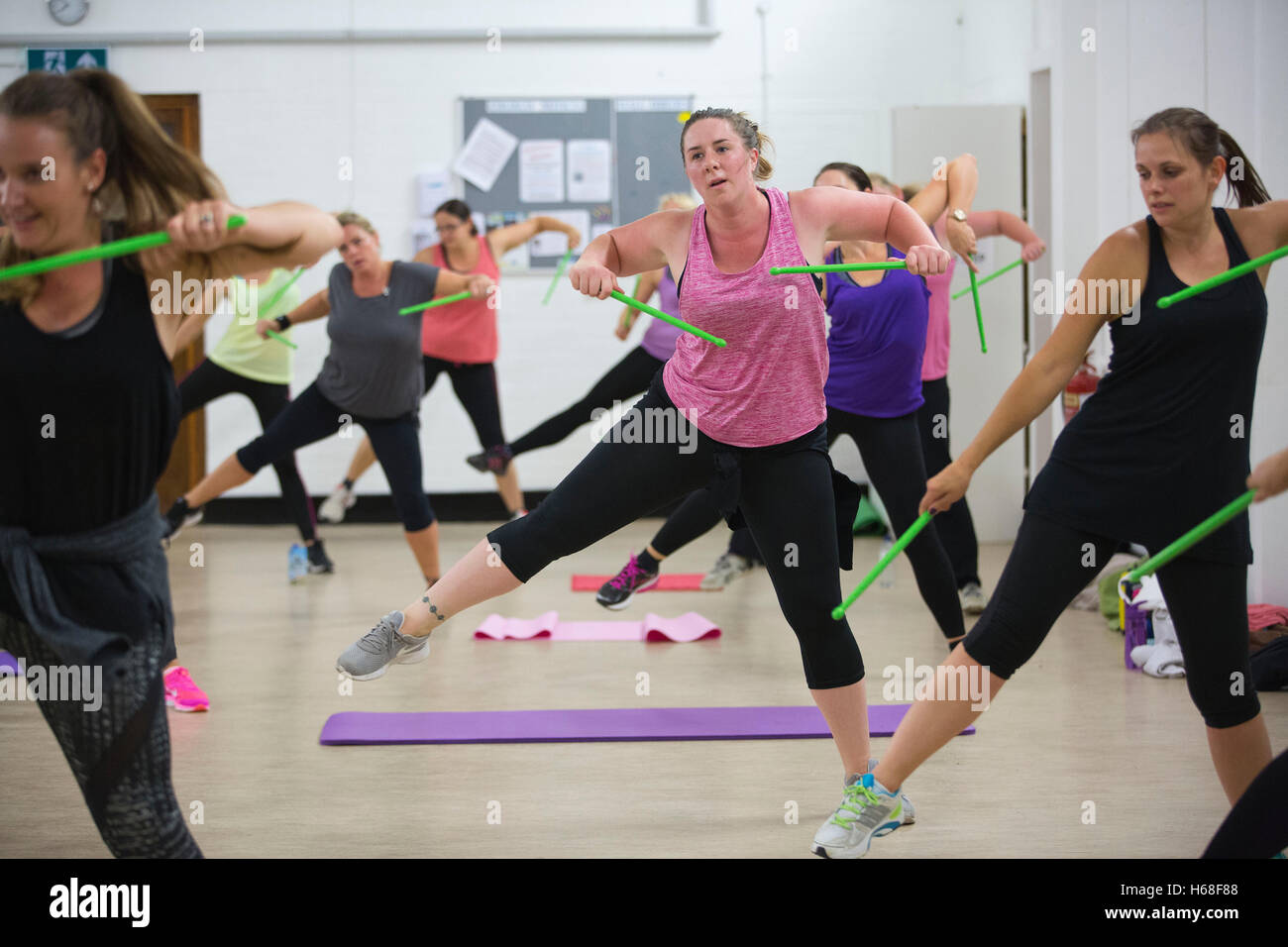Les femmes participant à des cours de conditionnement physique, LIVRE heure tambours d'entraînement qui augmente la force de noyau, Surrey, UK Banque D'Images