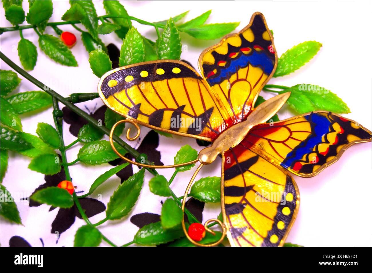False butterfly mis sur feuilles sur un fond blanc. Banque D'Images