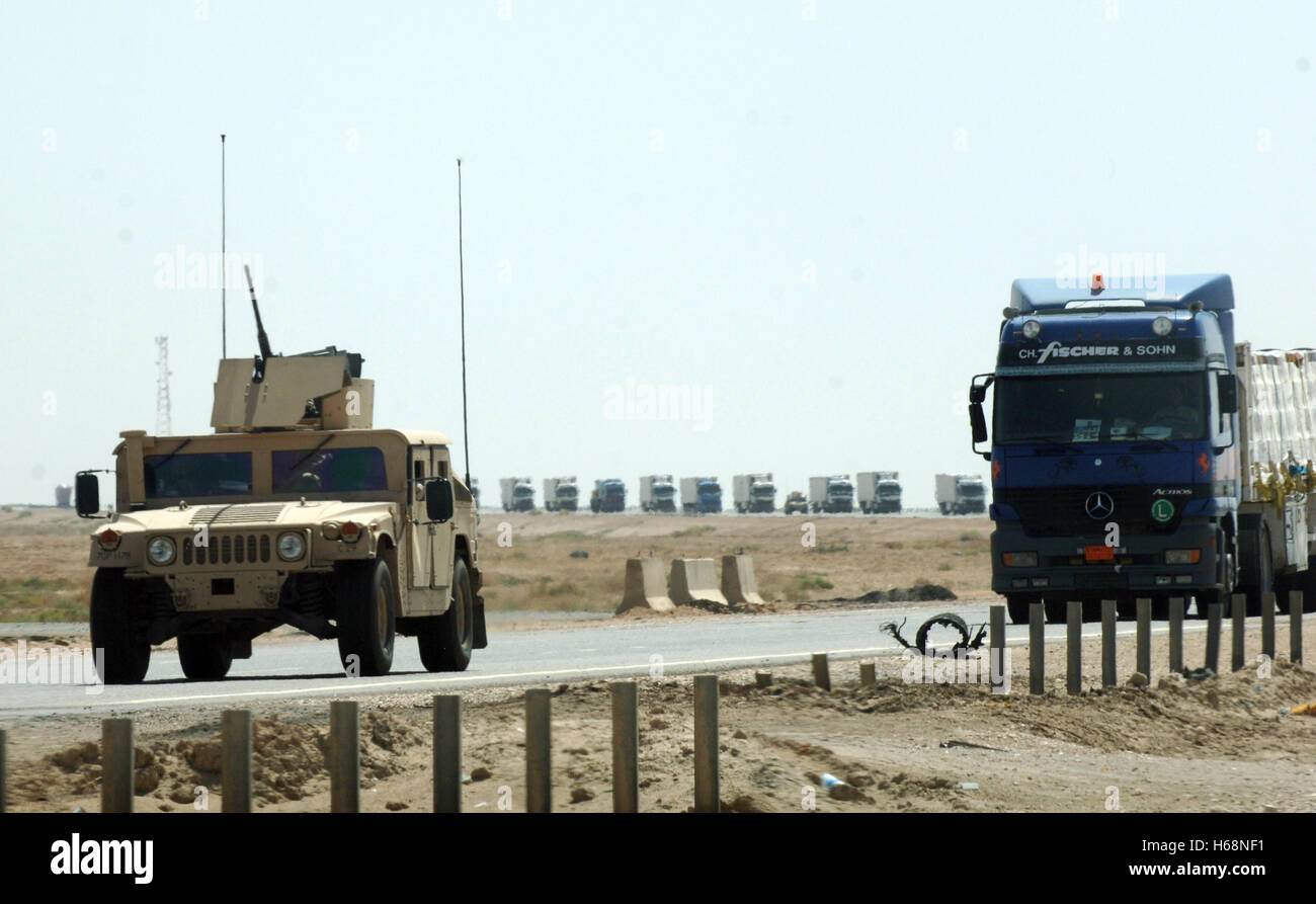 Un Humvee de l'armée américaine accompagne une longue file de camions-remorques qu'ils traversent le désert en Iraq. Les convois de camions rassemblent des milliers de tonnes de fournitures aux États-Unis et les forces de la coalition en Irak. DoD photo par le Sgt. Maurice Hessel, U.S. Air Force Banque D'Images