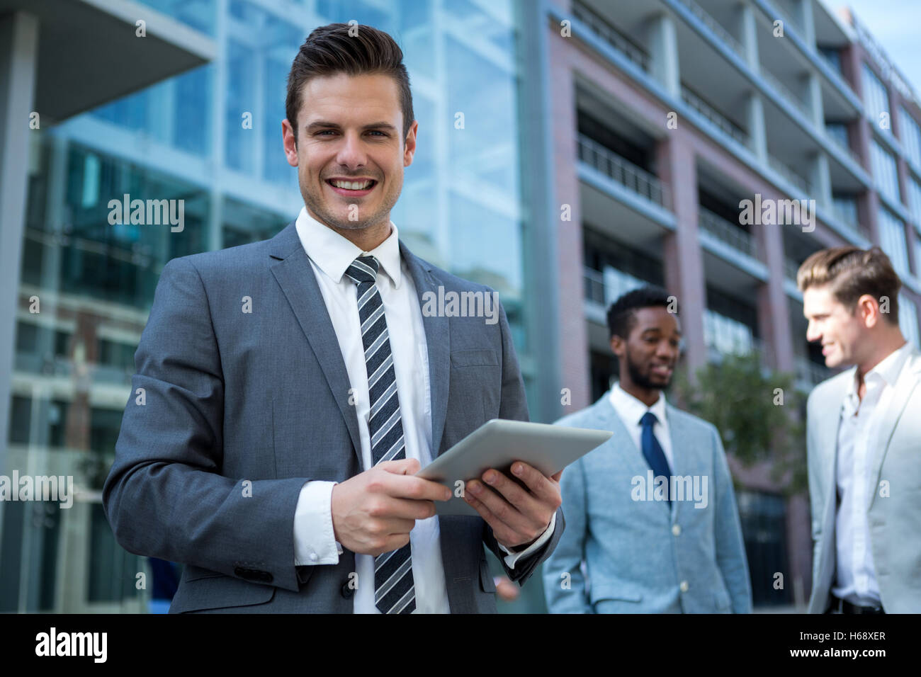 Smiling businessman using digital tablet in l'immeuble de bureaux Banque D'Images