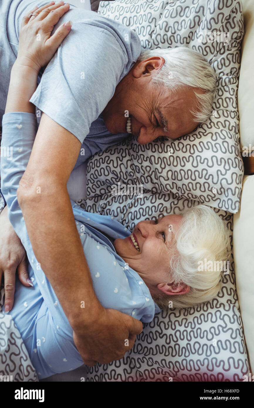 Senior couple embracing on bed Banque D'Images