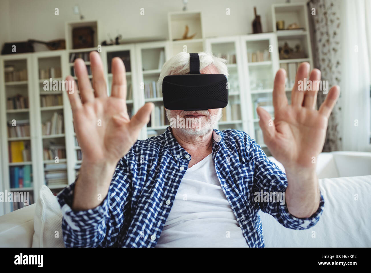 Hauts homme portant un casque de réalité virtuelle dans la salle de séjour Banque D'Images