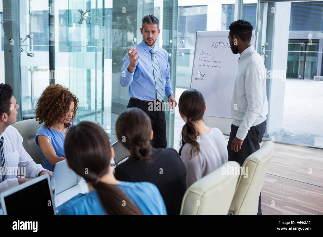 Businessman discuter sur tableau blanc avec vos collègues Banque D'Images