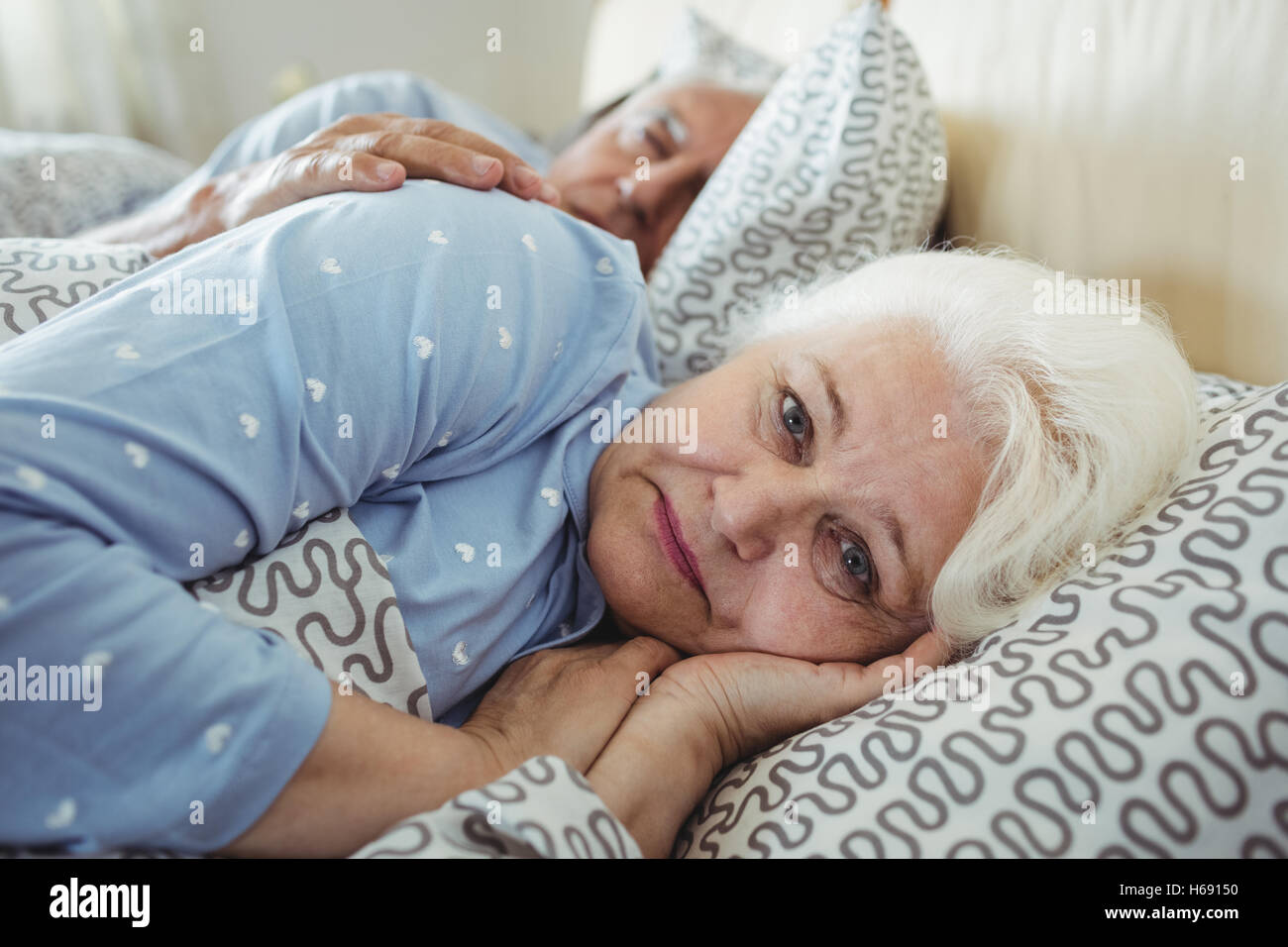 Senior woman awake on bed Banque D'Images
