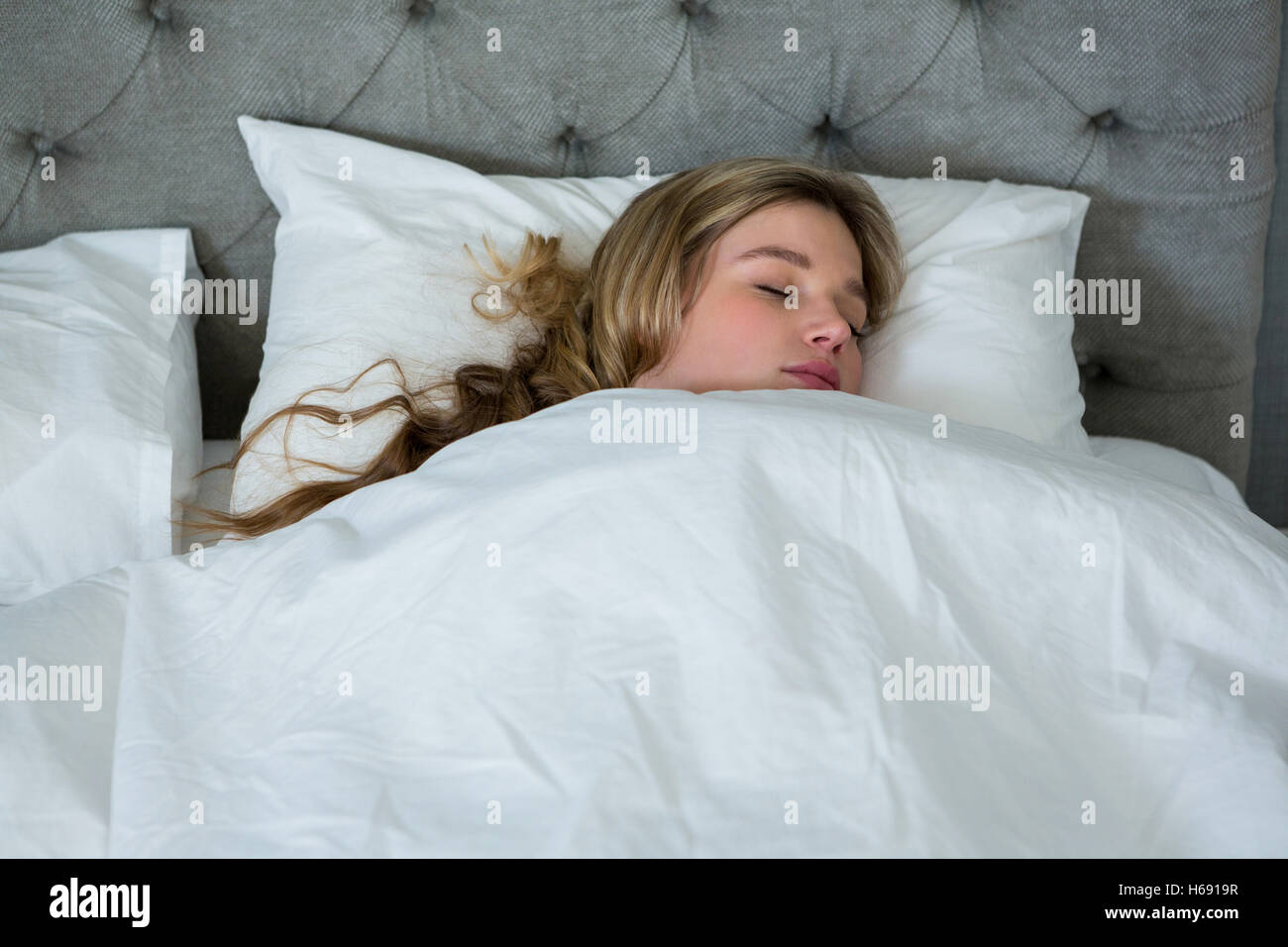 Jeune femme dormir sur son lit Banque D'Images