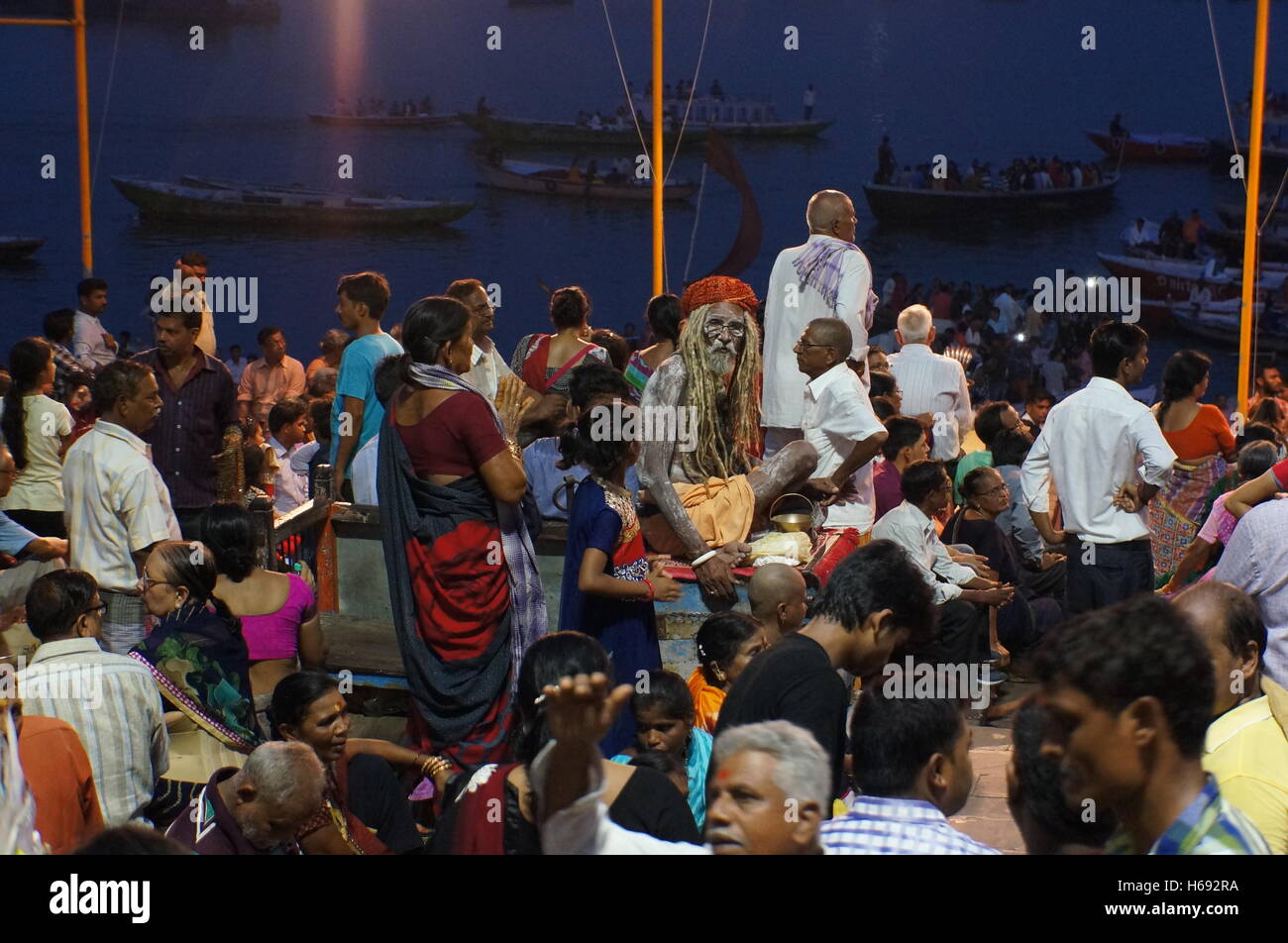 Un saint homme hindou, sadhu, couverte de cendres des morts, se dresse au milieu de la foule assistant à la Ganga Aati montrent à Varanasi, Inde. Banque D'Images