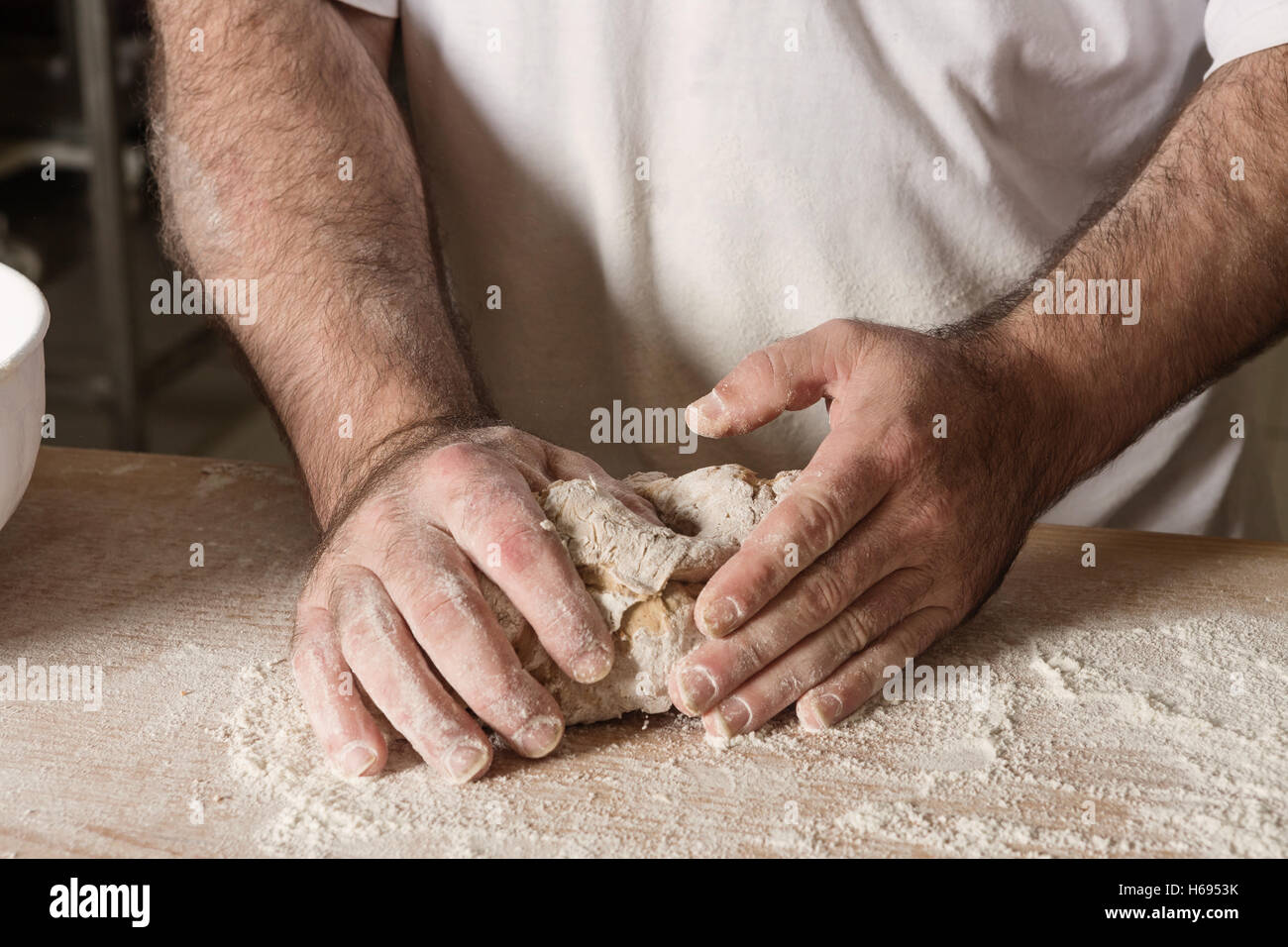 Détails sur part baker le pétrissage pâte sur un tableau noir avec de la farine en poudre. Le concept de la boulangerie et pâtisseries. Banque D'Images