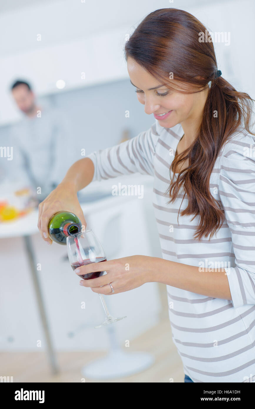 Woman pouring red wine dans un verre Banque D'Images