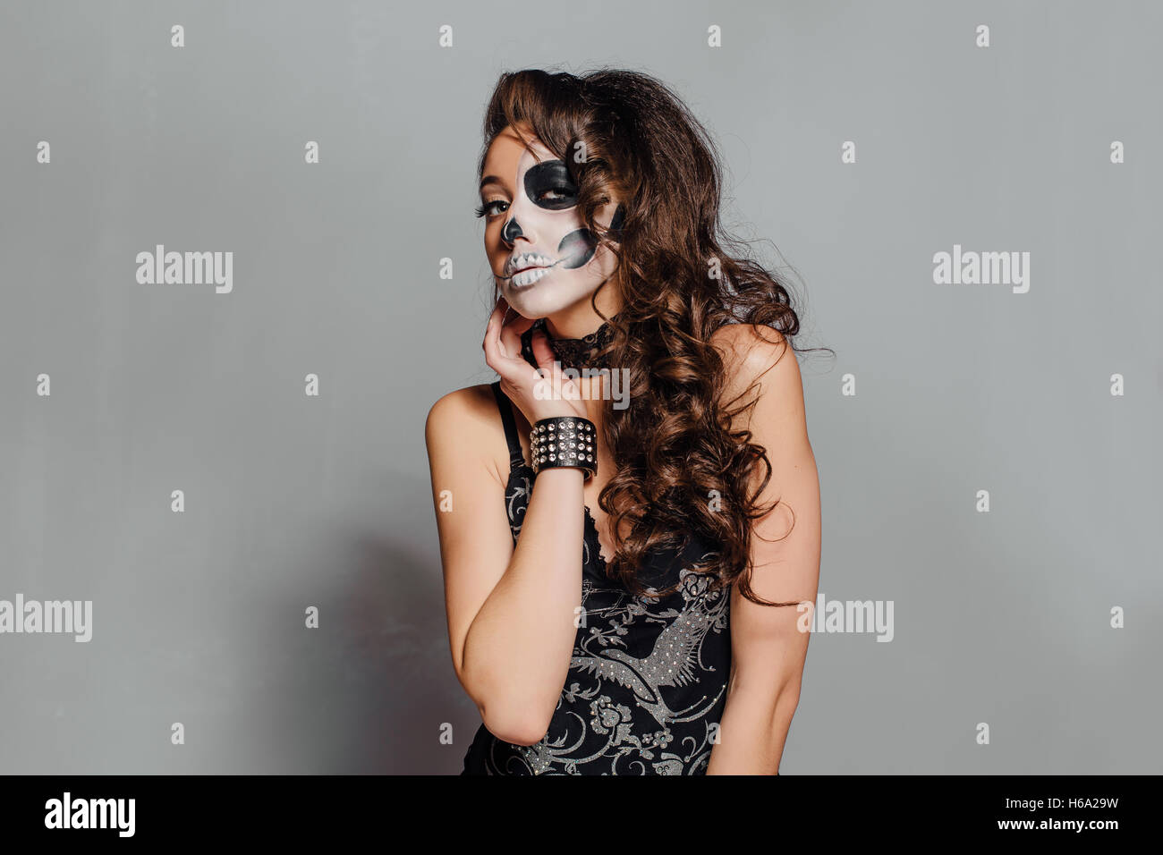 Jeune femme en noir avec la moitié du crâne face make-up. Banque D'Images