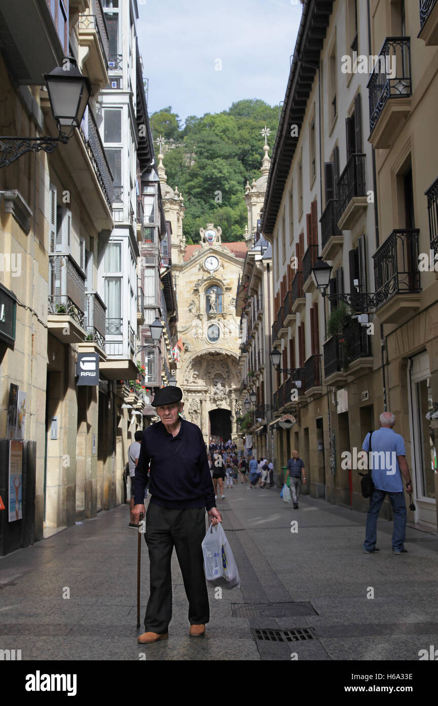 Vieil homme avec sac d'épicerie dans le centre-ville de San Sebastian / Donostia dans le pays Basque Espagne Banque D'Images