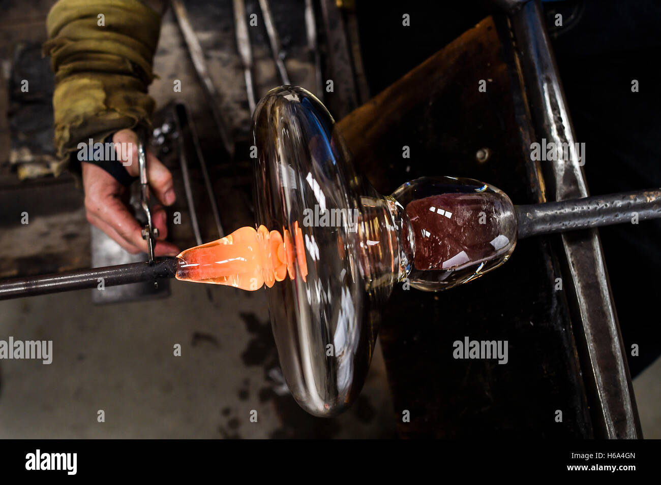 Souffleur de verre spécialiste James Devereux utilise des ciseaux pour verre  en fusion guide prêt pour la fusion qu'il fait le verre clair cocardes pour  une sculpture dans son atelier dans le