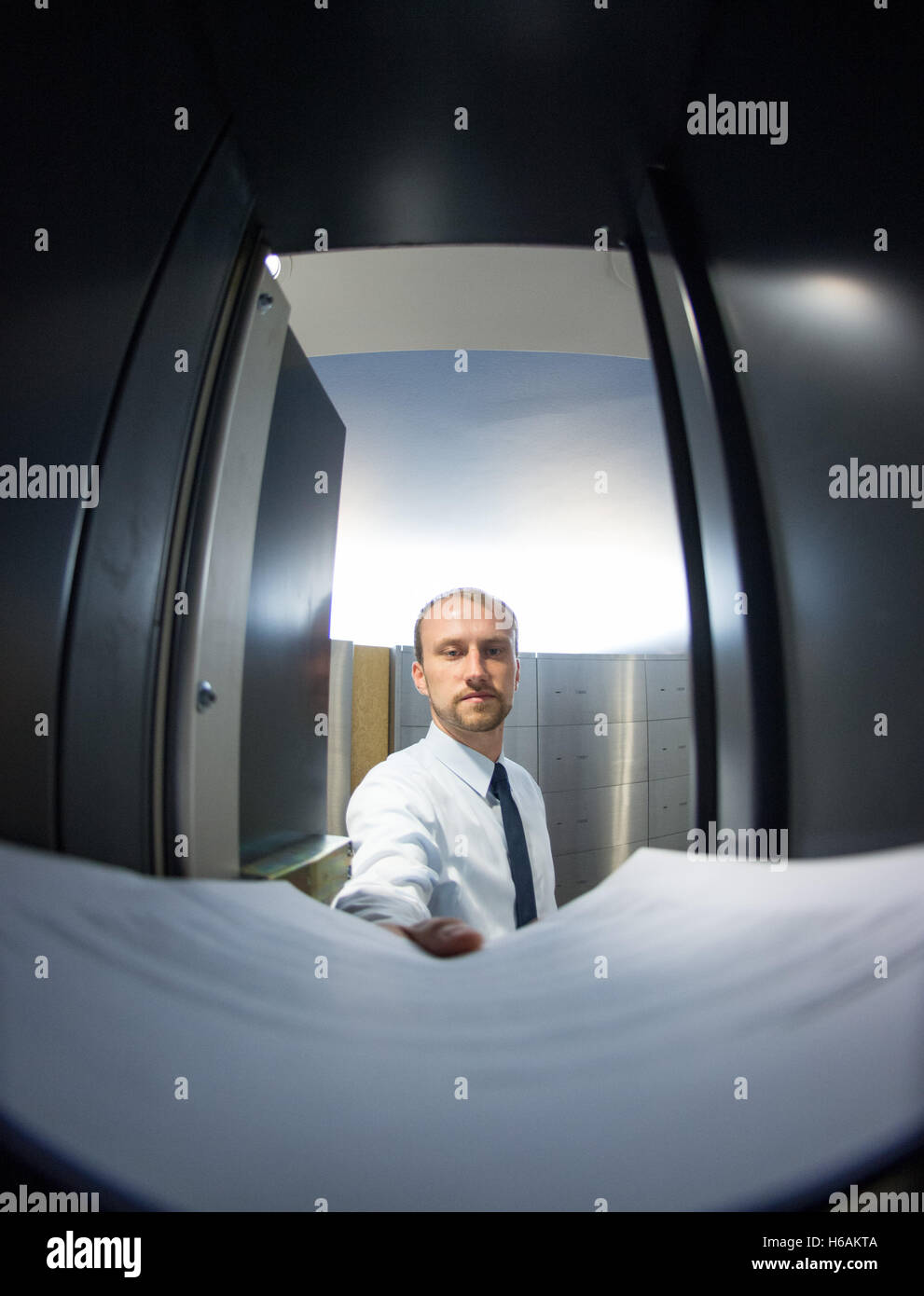 ILLUSTRATION - Un employé de la Sparkasse ressemble à un coffre-fort dans une succursale bancaire à Hambourg, Allemagne, 13 octobre 2016 Fake (scène). Trois étages au-dessous de la surface, les clients peuvent stocker vos objets dans environ 3500 coffres-forts. Photo : Daniel Reinhardt/dpa Banque D'Images