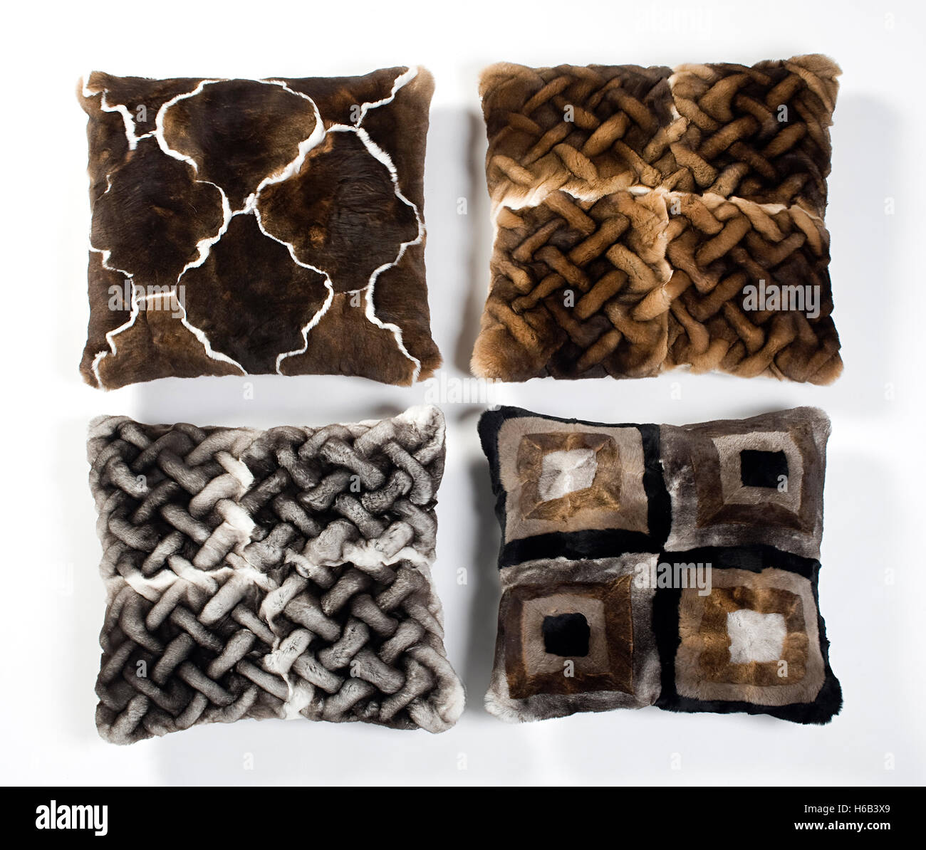 Quatre coussins de fourrure avec différents dessins géométriques dans des tons de brun disposées côte à côte Banque D'Images