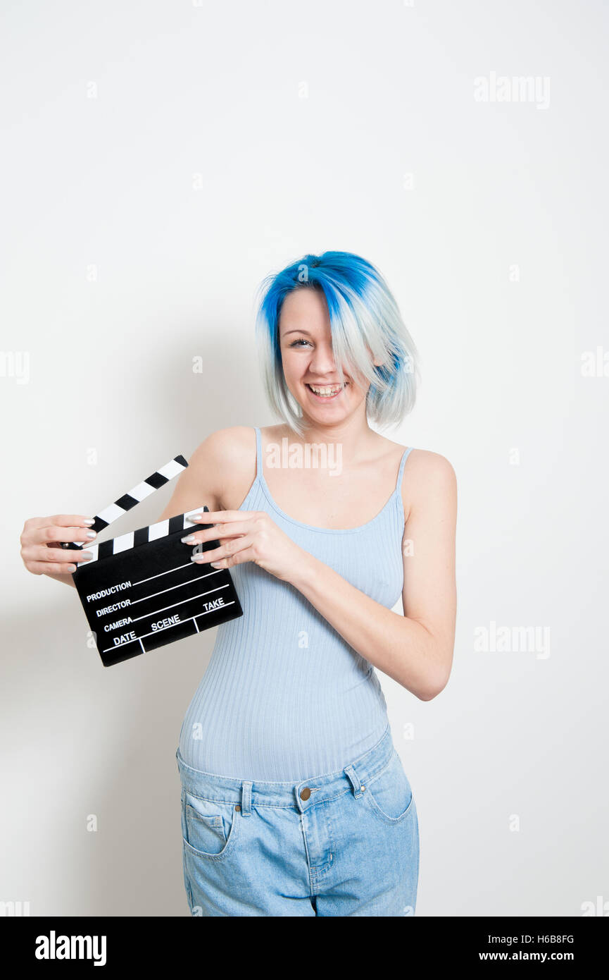 Alternative teen girl smiling et posant sur fond blanc avec movie clapper board pour l'actrice audition Banque D'Images