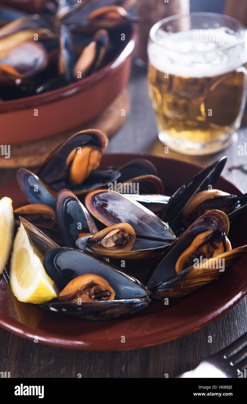 Les moules fraîches cuites avec du citron et de la bière Banque D'Images