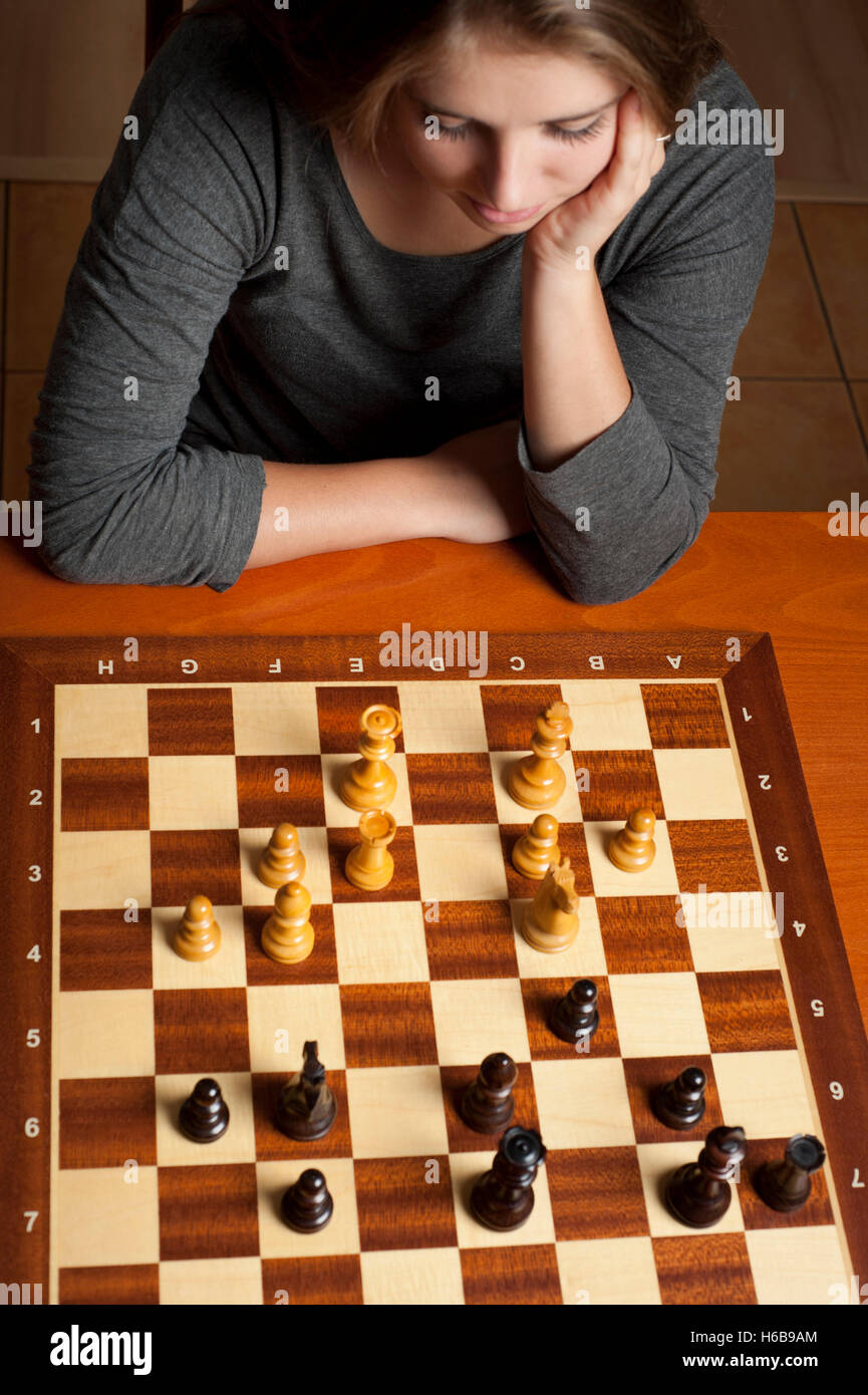 Tween brunette girl playing Chess game Banque D'Images