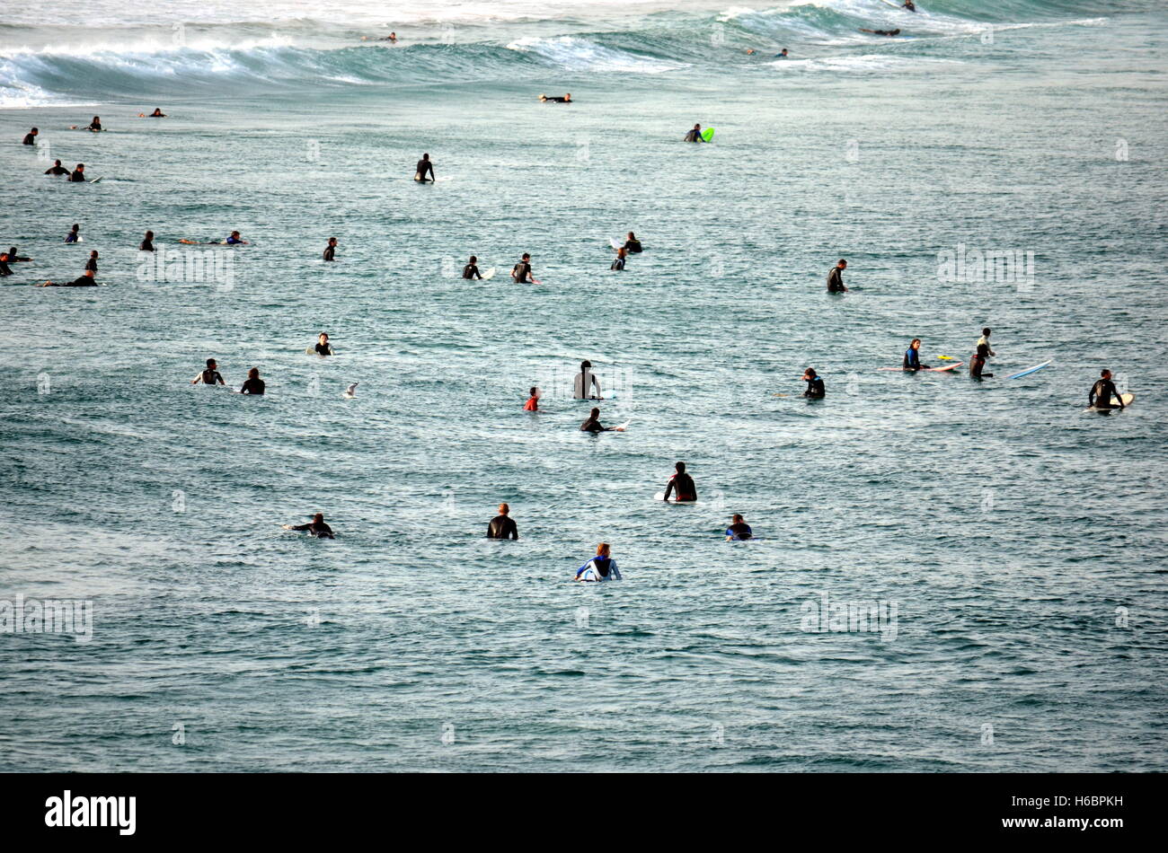 Sydney, Australie - Jun 9, 2013. Les surfeurs s'asseoir sur des planches de surf, attendre grand océan vague. Les gens dans l'eau sport adventure camp, la BEAC Banque D'Images