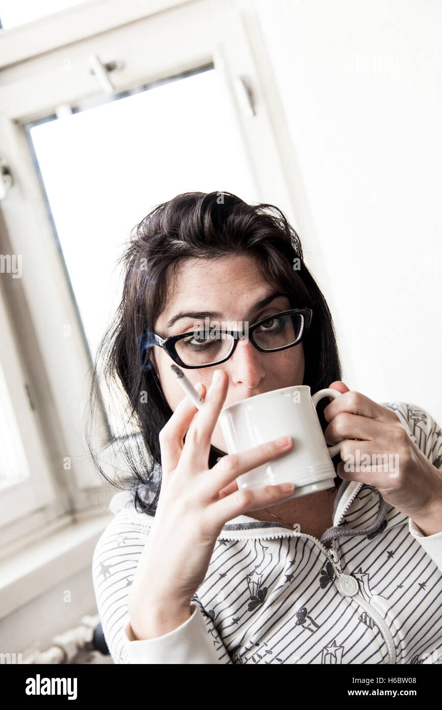 Une femme de boire son café du matin et fumer sa cigarette du matin. Très réaliste. Banque D'Images