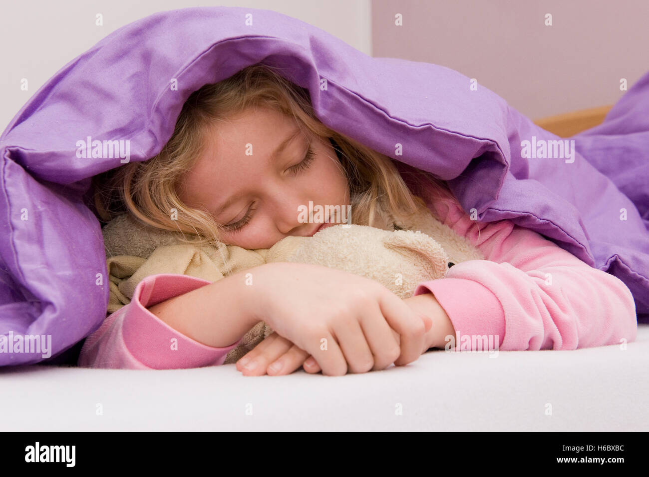 Jeune fille endormie sous couvre-lit Banque D'Images