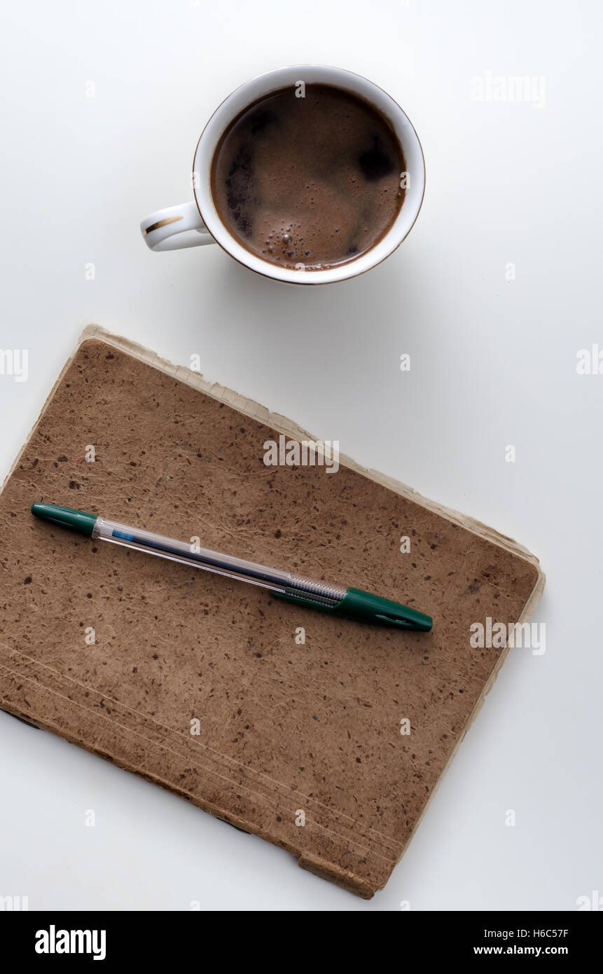 Le café, le bloc-notes et crayon, sur le bureau. Banque D'Images