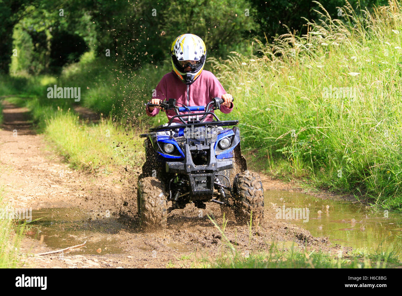 Équitation, quad sur piste boueuse farm Banque D'Images