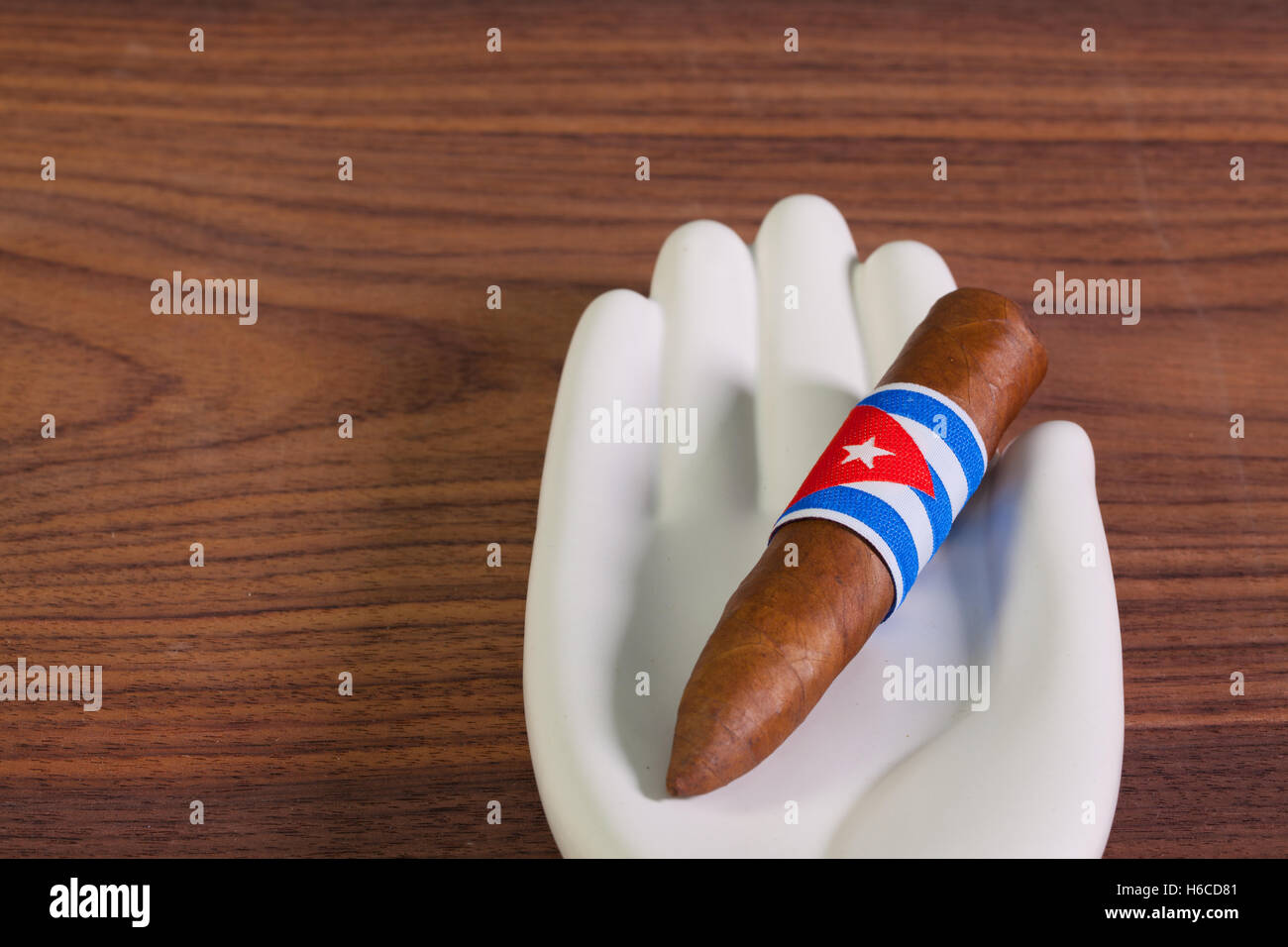 Cigare cubain de luxe en céramique de main et sur la table en bois. Banque D'Images