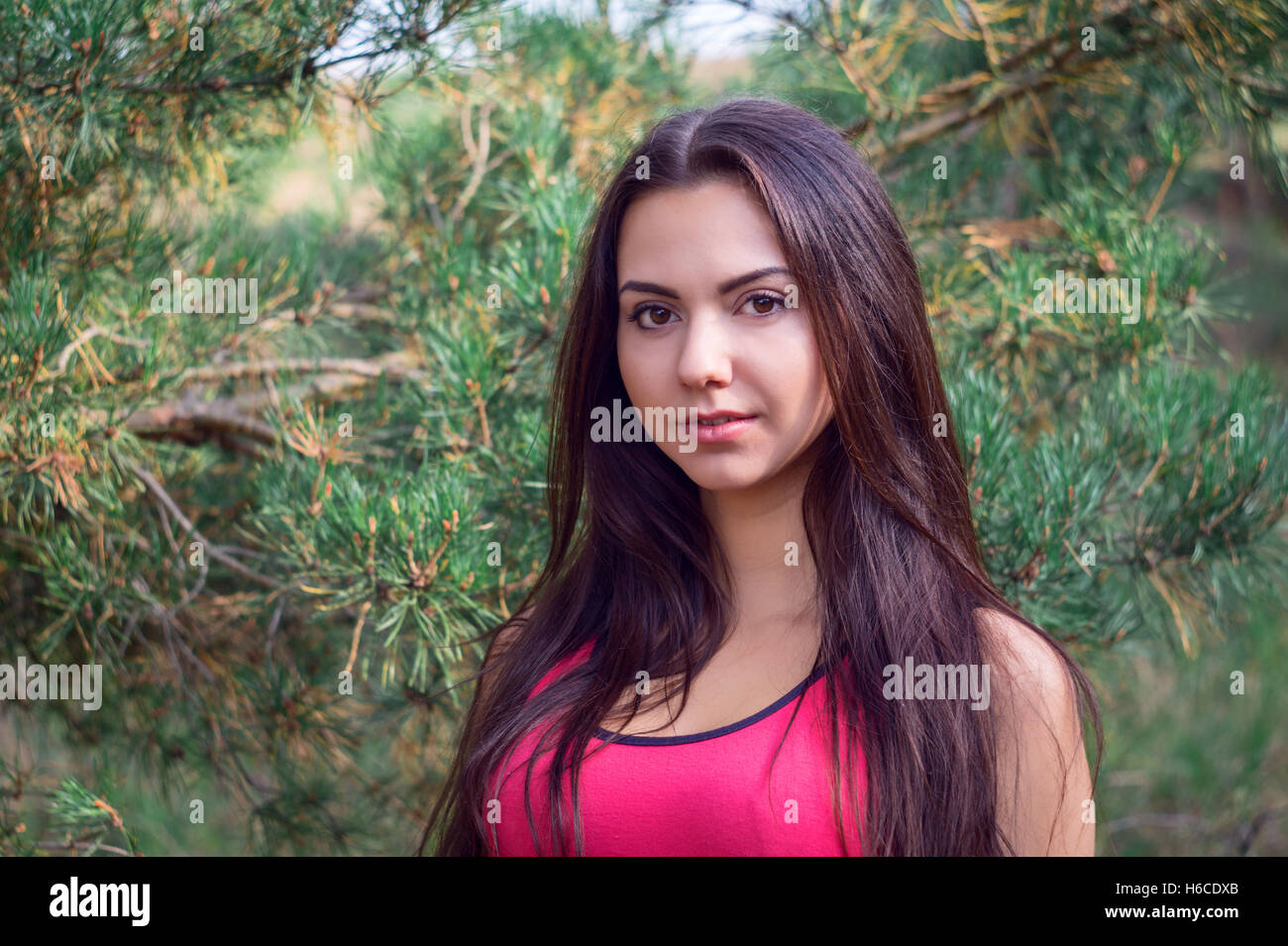 Jeune belle brunette model posing dans l'image du parc des sports dans le cadre d'arbres Banque D'Images