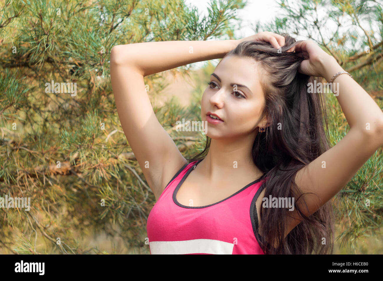 Jeune belle brunette model posing dans l'image du parc des sports dans le cadre d'arbres Banque D'Images