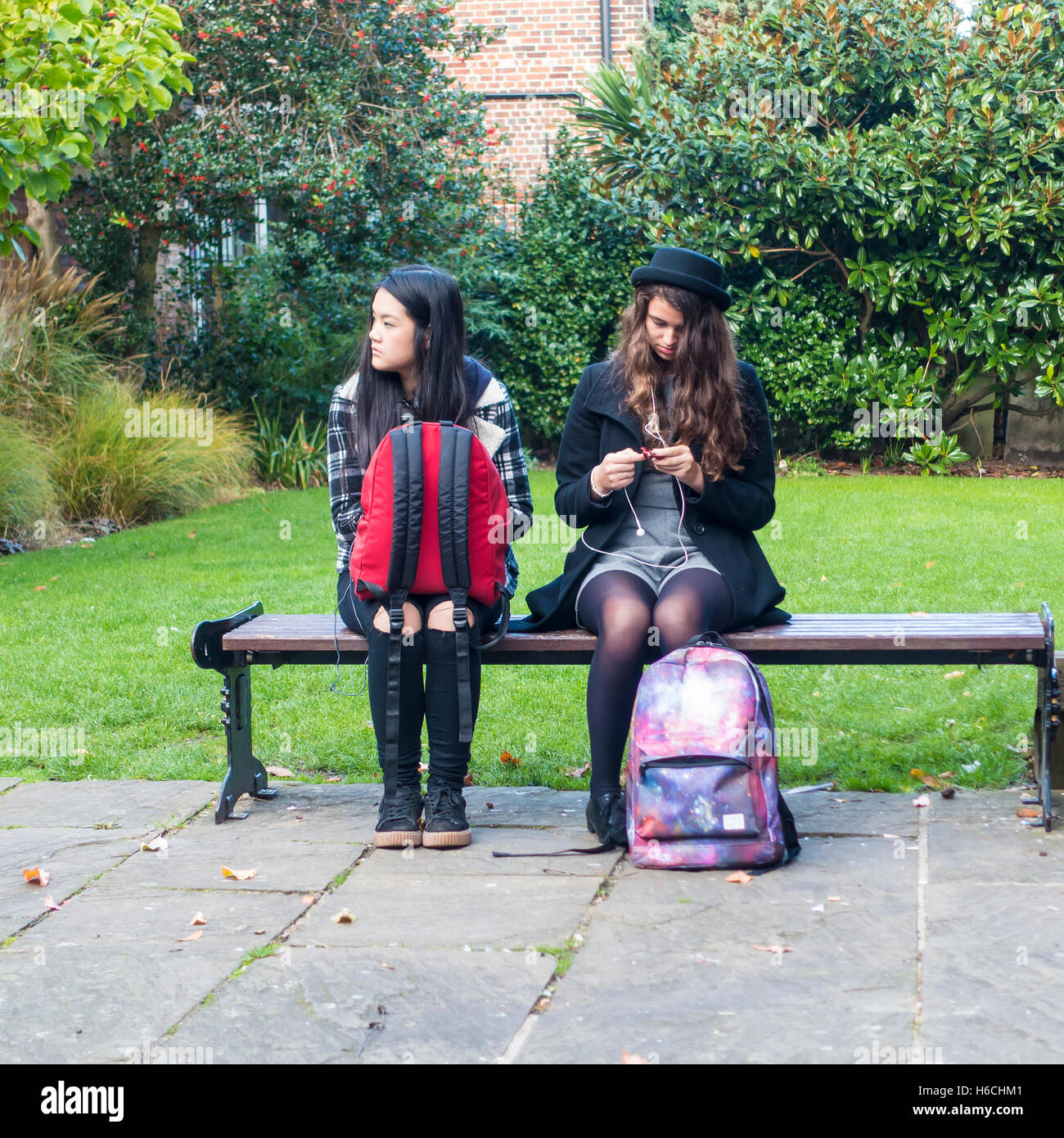 Deux étudiantes, assis sur un banc du centre-ville de Canterbury en Angleterre Kent Banque D'Images