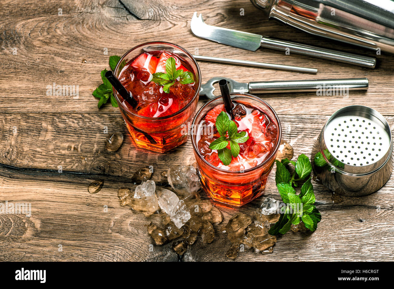 Cocktail rouge avec des feuilles de menthe, fraise, glace. Plateau bar tools Banque D'Images